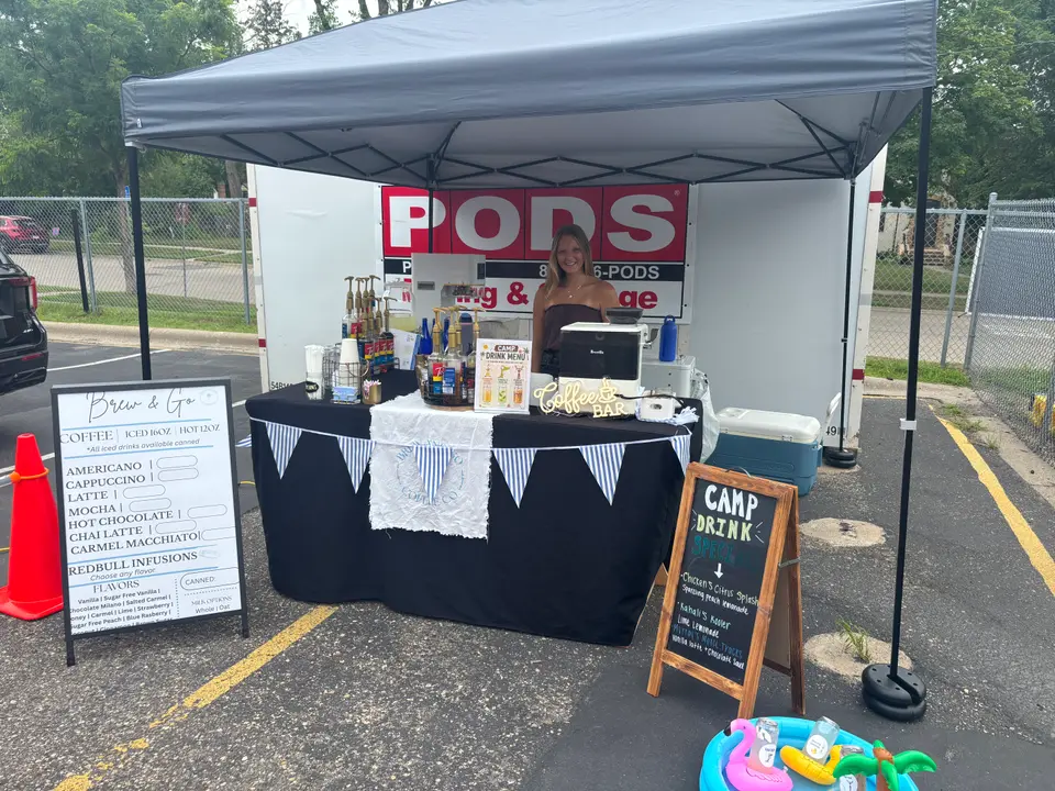 Her tent bar at an outdoor event, menu board out front